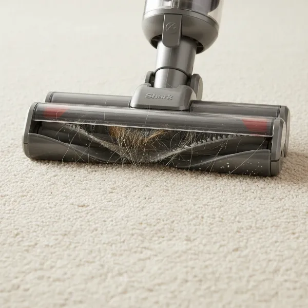 Close-up of Shark Wandvac's PowerFins floorhead actively cleaning pet hair from a carpet.